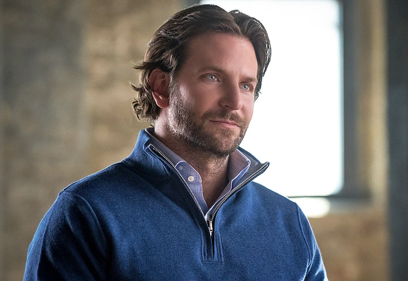 Edward Morra in a blue quarter-zip sweater, looking off to the side with a confident smile