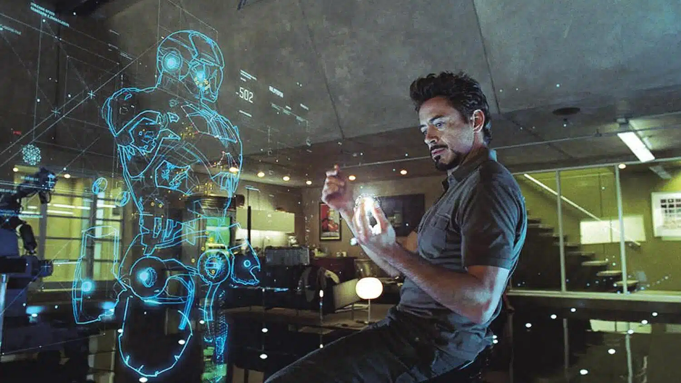 Tony Stark manipulating a holographic blueprint of an Iron Man suit in his lab
